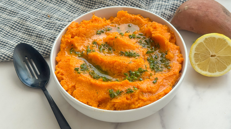 Bowl of whipped sweet potatoes with herb drizzle