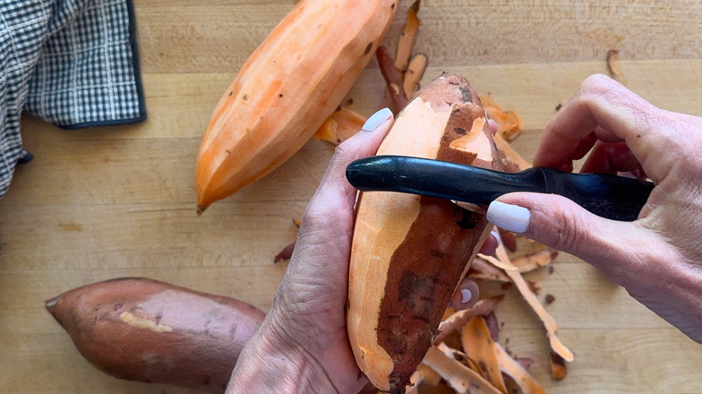 hands peeling sweet potatoes