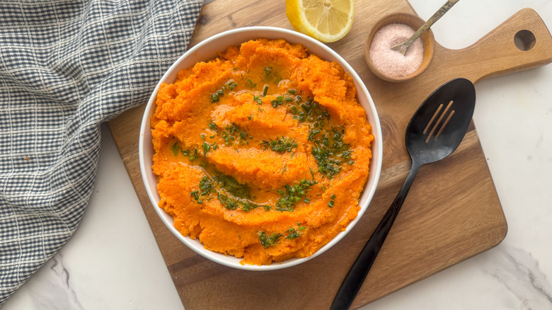 Bowl of mashed sweet potatoes with herb drizzle