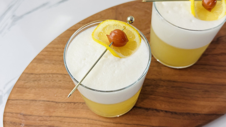 Whiskey sour with egg white foam and garnishes