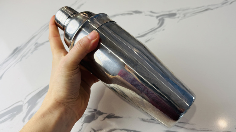 Shaking whiskey sour ingredients