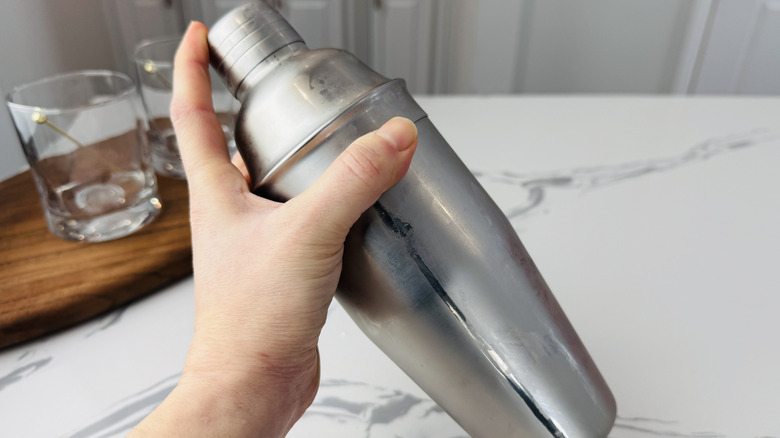 Shaking whiskey sour in cocktail shaker