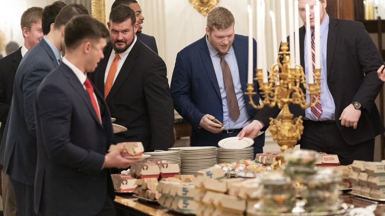 Members of the Clemson Tigers football team prepare to dine on burgers, fries, and other fast food served by Donald Trump at the White House in honor of their national championship in January 2019.