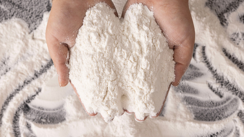 Cook holding a batch of flour