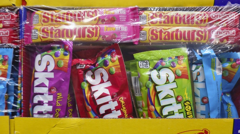 an assortment of skittles products with packs of starburst
