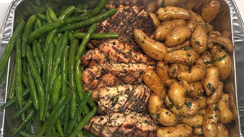 Closeup of one Whole Foods Market Family Meal Deal consisting of green beans, grilled salmon, and fingerling potatoes