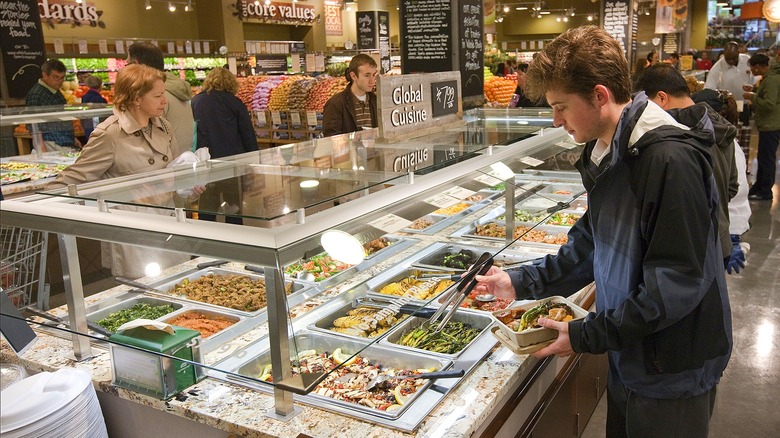 Whole Foods Market customers shopping the self-serve prepared food bar