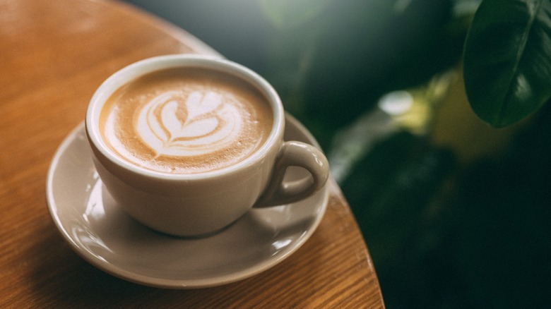 Cappuccino with a saucer on a round wooden table