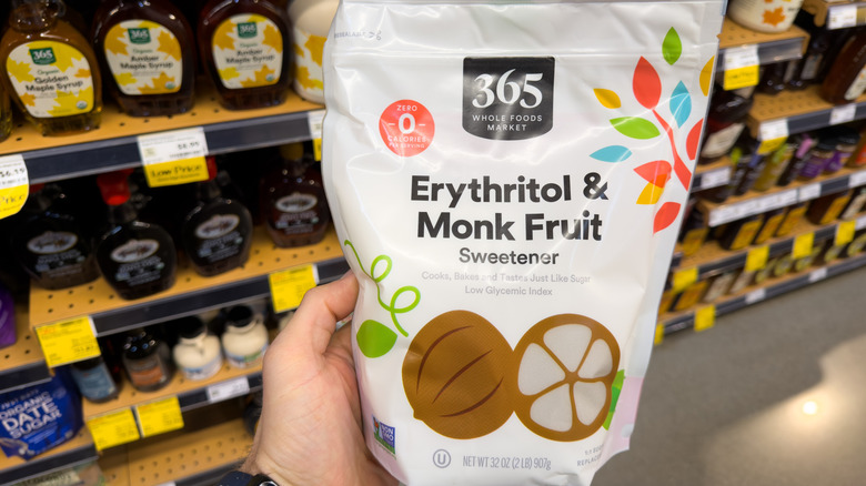 A person holds a bag of erythritol and monk fruit sweetener