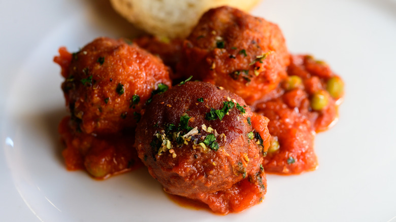 Italian meatballs with sauce on a white plate.