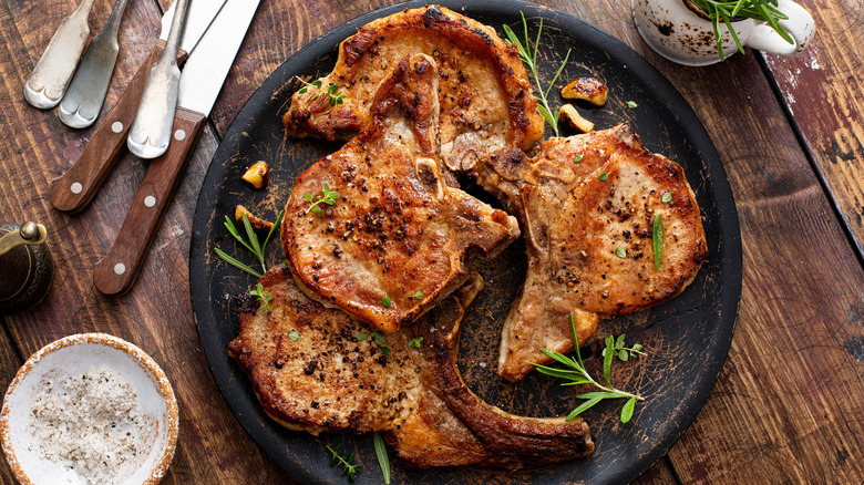 A plate of cooked pork chops pictured from overhead.