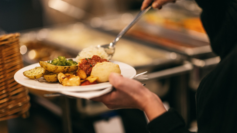 Person filling buffet plate
