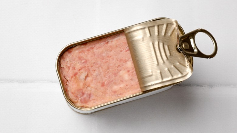 A can of meat with the top pulled back, showing the packaged meat within.