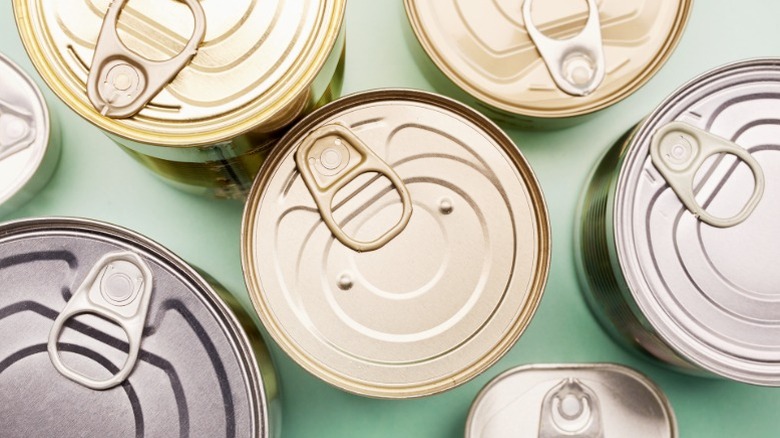 Various food tin cans for meat and other goods shown with the tops closed.