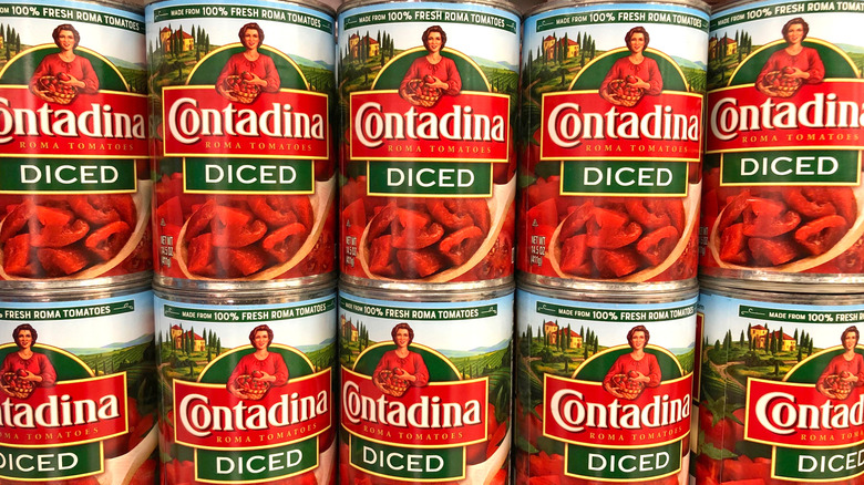Rows of Contadina canned diced tomatoes on a supermarket shelf.