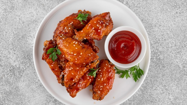 A plate of spicy chicken wings with sauce