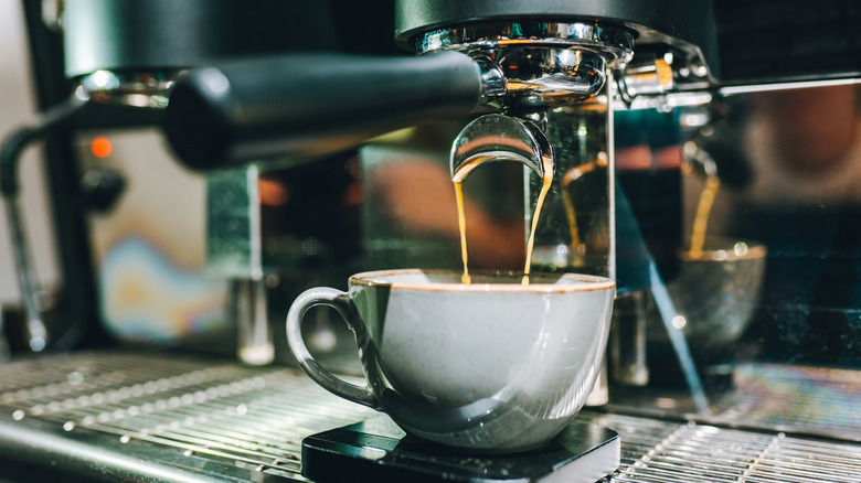 An illustrative image showing fresh hot espresso pouring in a cup.