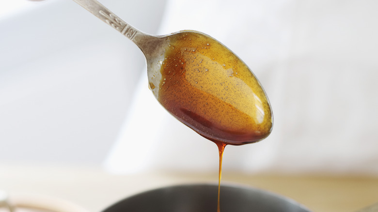 simple syrup dripping off a spoon into a saucepan