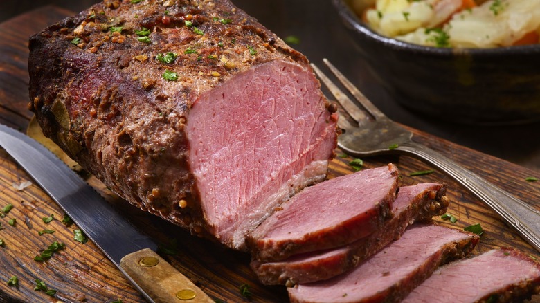 Seasoned corned beef brisket on cutting board