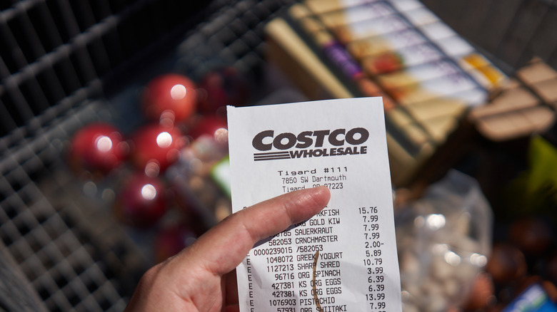 Costco receipt with cart of groceries in the background