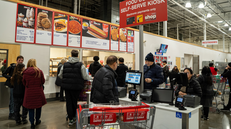 People are seen standing around a Costco food court.