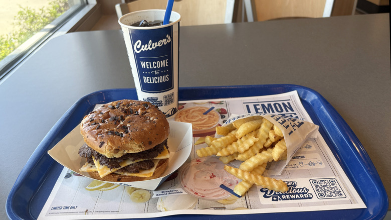 A Culver's double cheeseburger, French fries, and a soda sit on a tray on a table at one of the Wisconsin chain restaurant's locations.