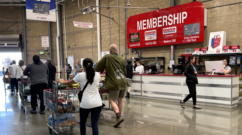 line of people inside a Costco in front of the service counter