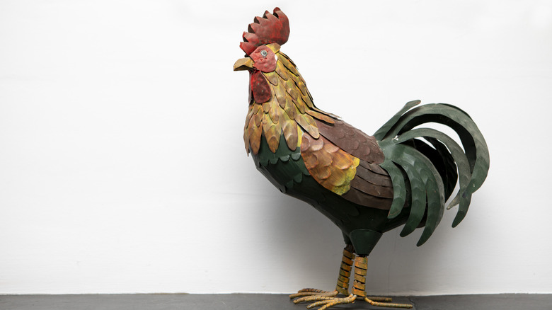 a colorful rustic steel rooster on white background