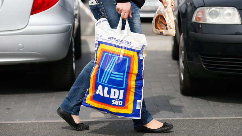 Person carrying a plastic Aldi bag