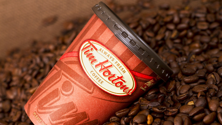A Tim Hortons coffee cup on a pile of beans.