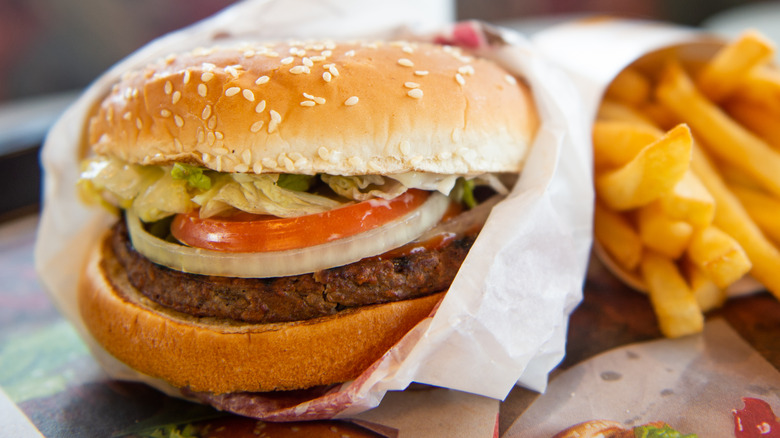A Burger King Impossible Whopper on a tray with fries.