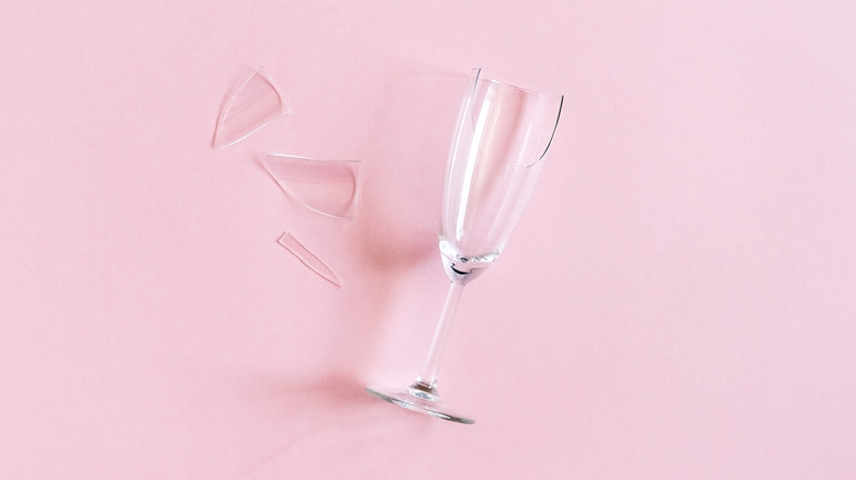 broken champagne flute glass on pink backdrop