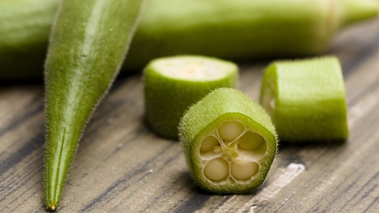Raw okra on a wooden surface