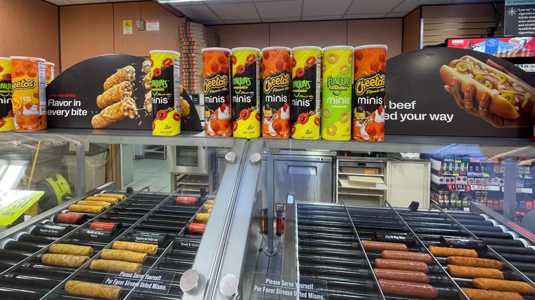 hot dogs and taquitos on a roller grill in a gas station