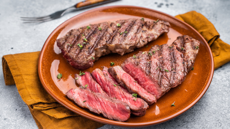 Cut pieces of rare steak on plate