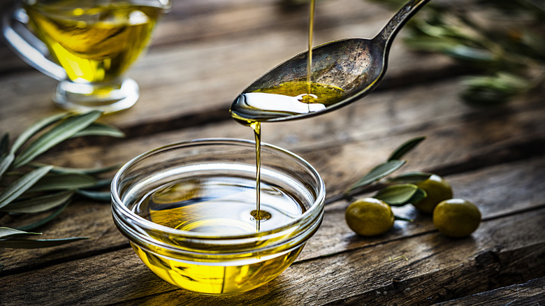 Olive oil drizzled into spoon