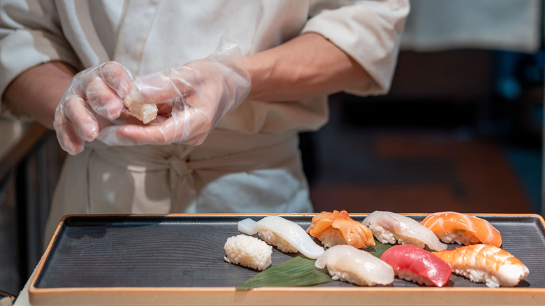 Koki sushi sedang menyiapkan nigiri sushi 