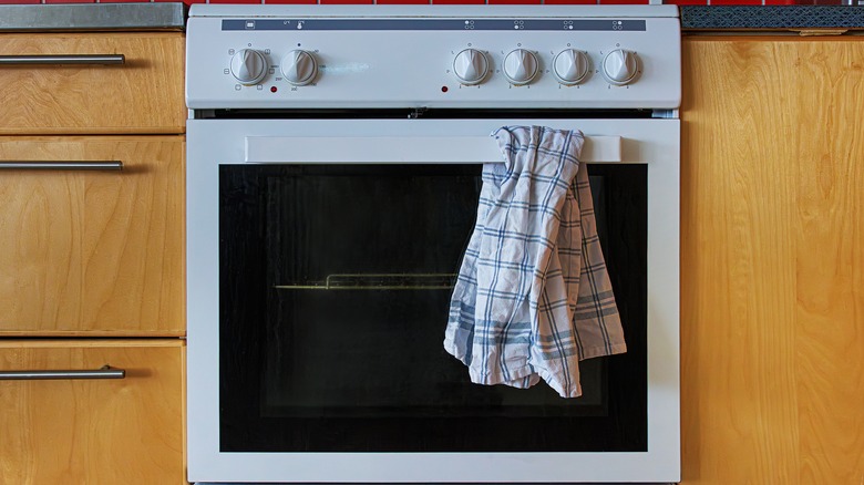 a used dish towel on an oven handle
