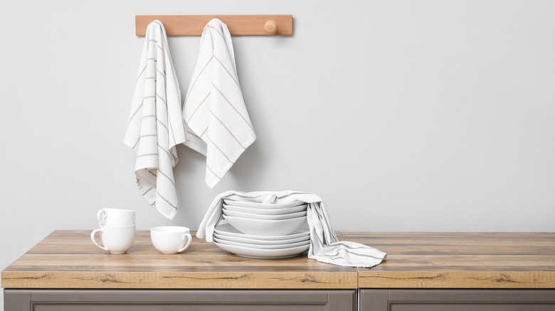 dish towels on a wooden rack and on white dishes