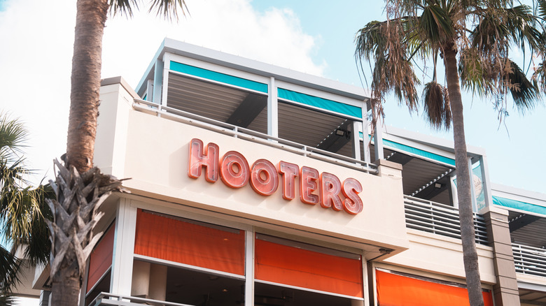 The facade of Hooters' original location in Florida, capturing a beach-bar vibe with palm trees and bright color accents