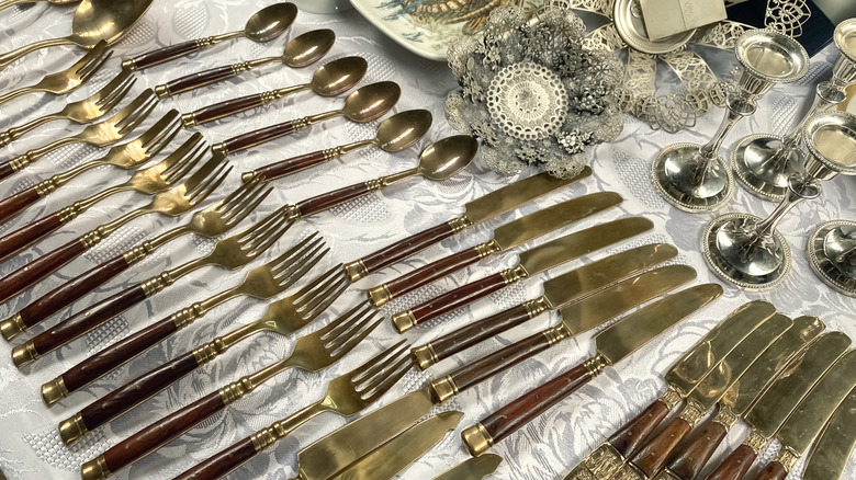 Vintage pieces of silver lined up on a table for resale