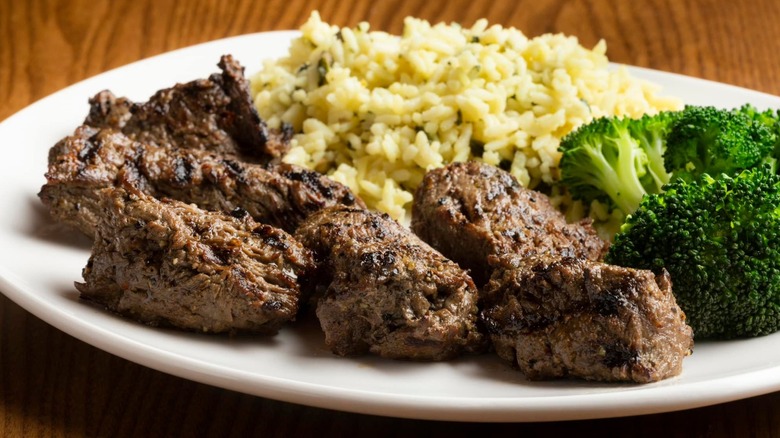 Steak tips on a plate with broccoli and rice