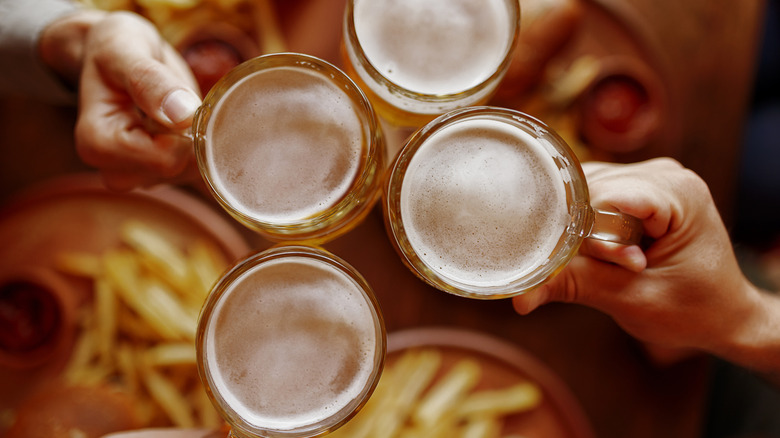 hands clinking over beer