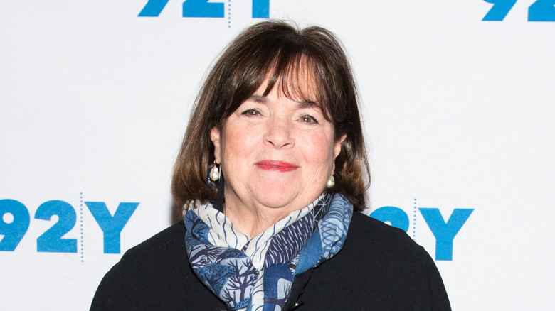 Ina Garten smiling, wearing a blue and white scarf and black top.