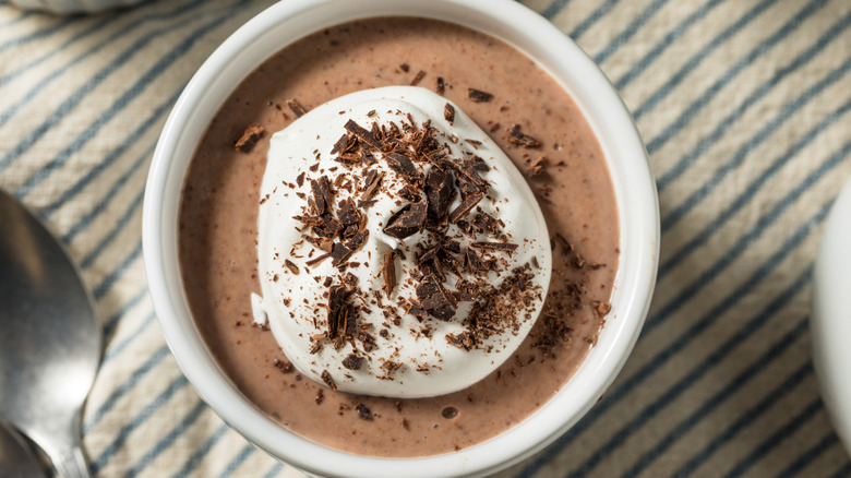 Chocolate pudding topped with whipped cream and shaved chocolate