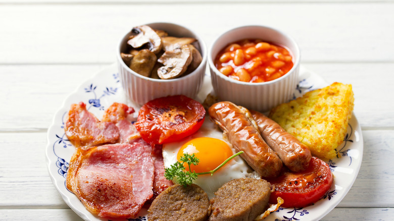 A traditional Irish breakfast plate containing meats, eggs, vegetables, and beans