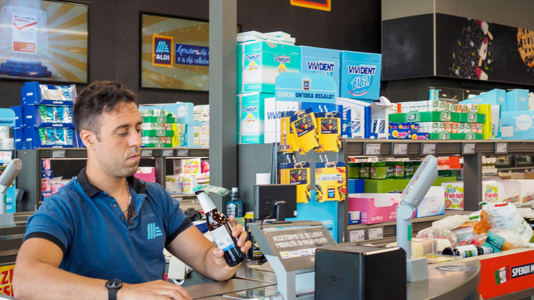 An Aldi cashier scans items through the checkout.