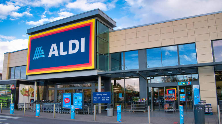 The large blue facade of an Aldi store looms over a parking lot