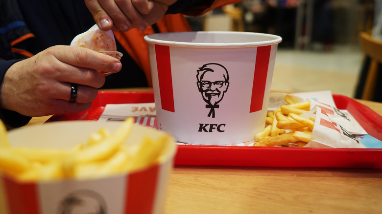 KFC chicken bucket on a tray and on a restaurant table.