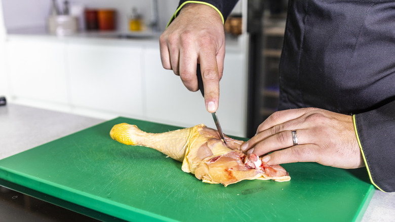 A person slicing chicken